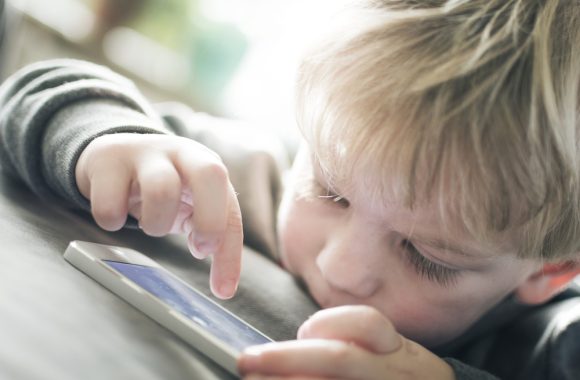 Vaikas su mobiliuoju telefonu